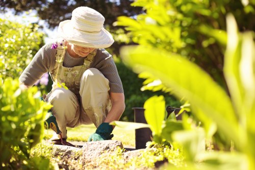 Gardener pruning a terraced front garden near Richmond Station